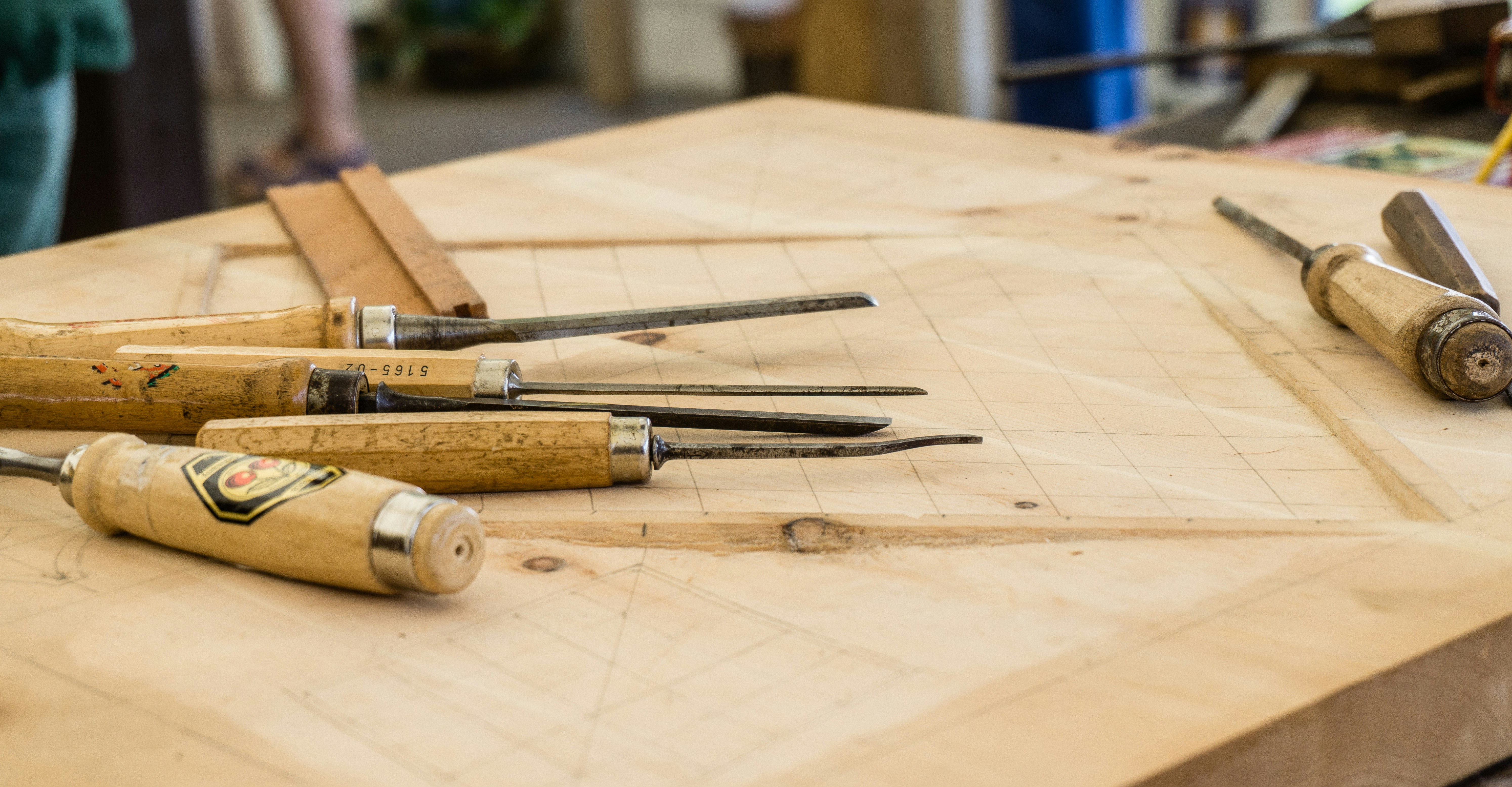 Woodturning chisels laid out on a fresh pine workbench in the Oak & Pine by Design workshop