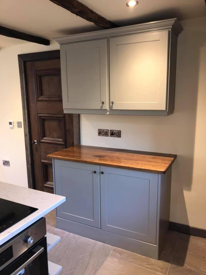 Handmade grey hand-painted Shaker kitchen with solid wood worktop, quartz-topped island, exposed beam and period panelled door — Oak & Pine by Design, Yorkshire