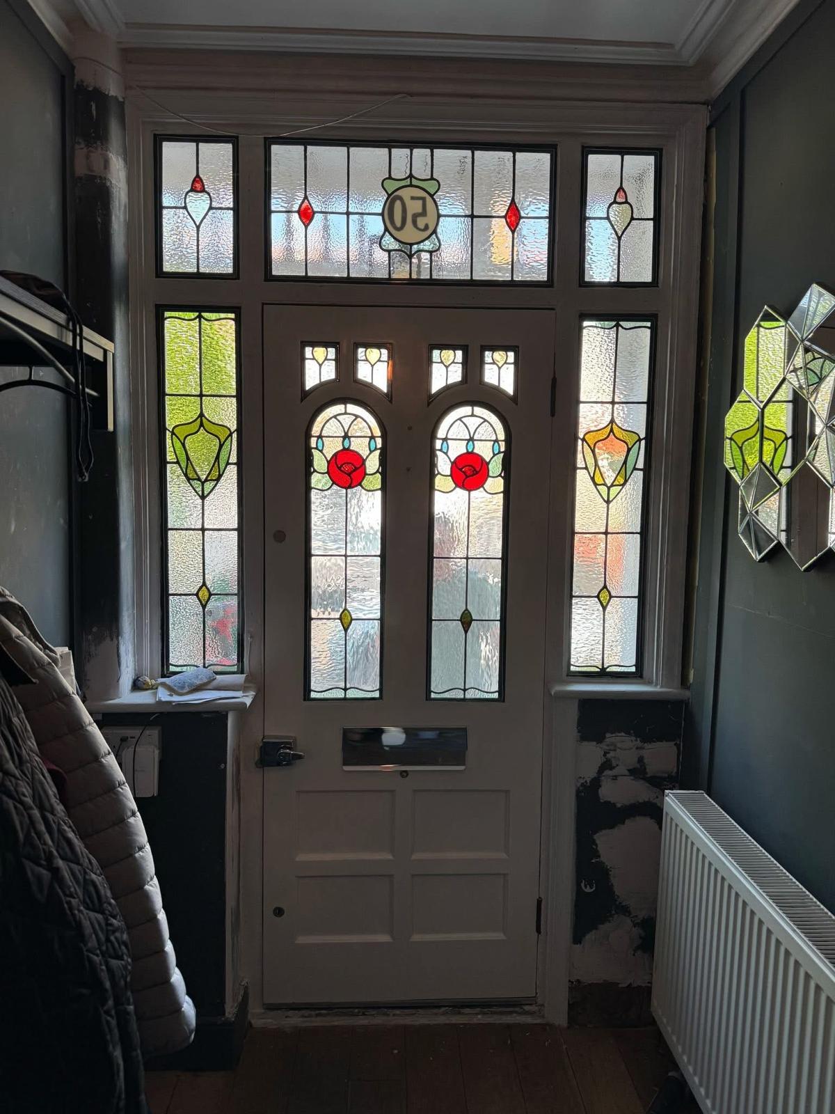 Interior view of a restored Edwardian stained-glass front door with red-rose leaded light detail, Yorkshire
